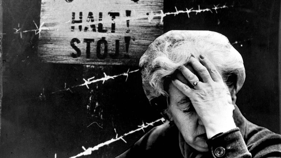 Женщина на фоне таблички "HALT STOJ"